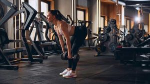 imagem com uma mulher realizando o exercício stiff com halteres