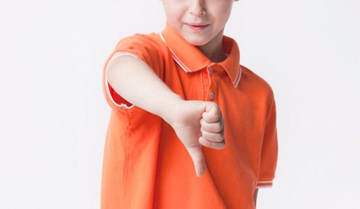 Criança com transtorno desafiador opositor fazendo um sinal negativo com a mão.