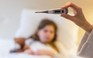 Mãe medindo a temperatura da filha