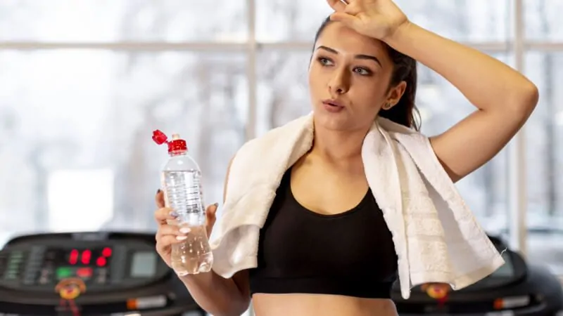 imagem de uma mulher praticando exercícios segurando uma garrafa de água