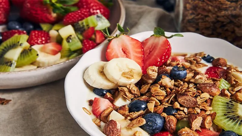 Imagem com uma tigela com granola e frutas para um café da manhã saudável