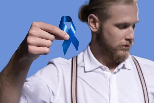 Homem segurando um laço azul de prevenção ao câncer de próstata.