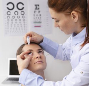 Médica aplicando colírio para caroço vermelho no olho