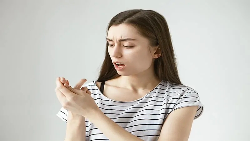 Imagem de uma mulher olhando para as unhas