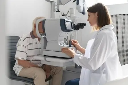Idoso com caroço no olho sendo examinado pela oftalmologista