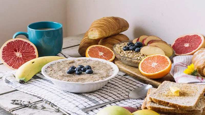 Imagem com pães, frutas e mingau de aveia