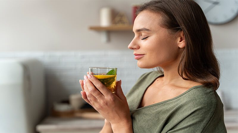 imagem de uma mulher tomando chá caseiro para infecção urinária