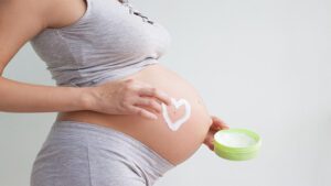 Imagem de uma mulher usando creme para estrias na gravidez