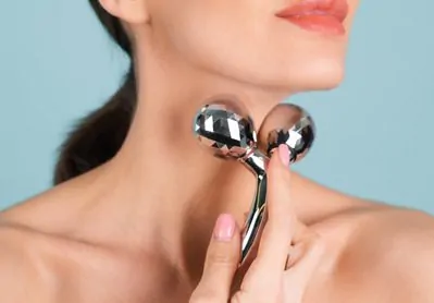 Mulher usando massageador de rosto