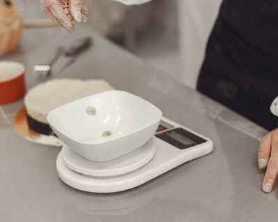 Mulher pesando porções de alimentos