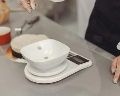 Mulher pesando porções de alimentos