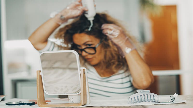 imagem de uma mulher aplicando o removedor de tinta de cabelo