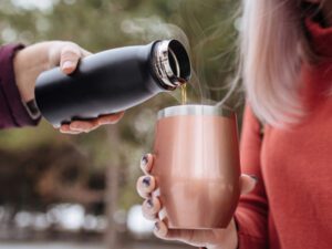 Mulher passando líquido de copo em copo