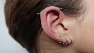 imagem de uma pessoa com pomada para piercing inflamado
