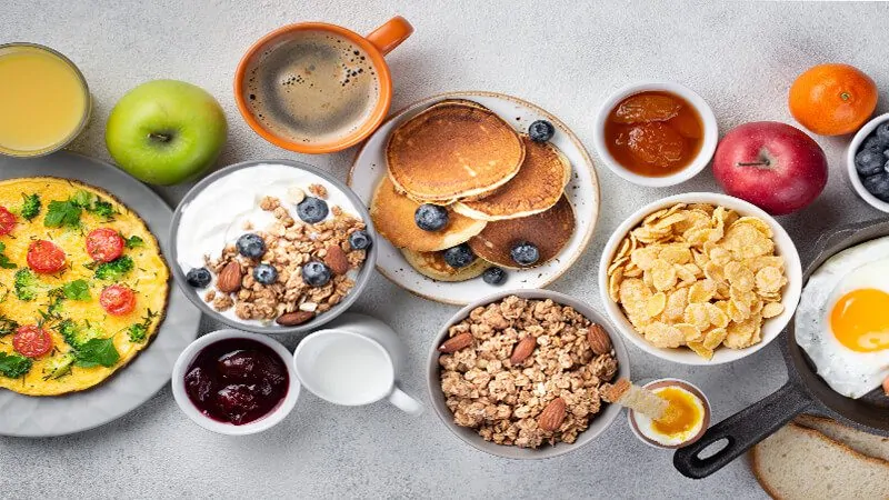 imagem de um café da manhã com frutas, cereais e proteínas