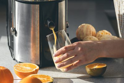 Mulher utilizando um espremedor de suco