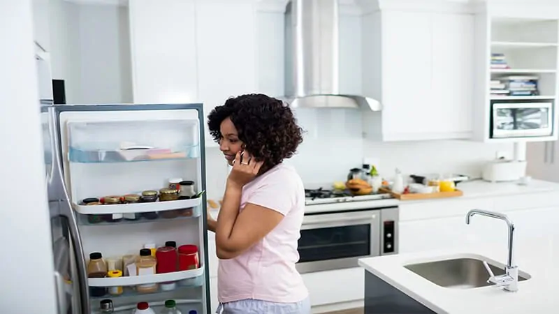 imagem de uma mulher olhando a geladeira