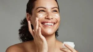 imagem de uma mulher aplicando um creme na pele