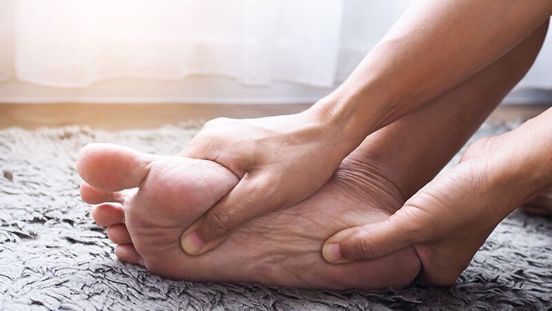 imagem de uma pessoa com a sola do pé coçando a noite