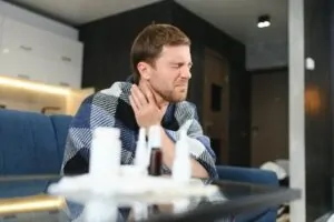 Homem com dor e com antibiótico para garganta inflamada