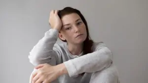 imagem de uma people pleaser pensativa com a mão na cabeça