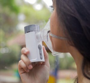 Mulher utilizando nebulizador portátil