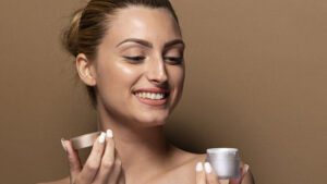 imagem de uma mulher aplicando um creme no rosto