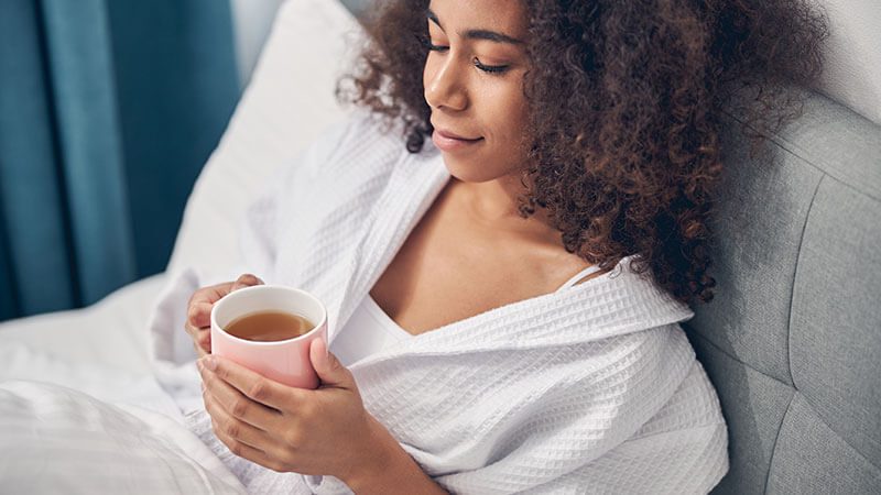 imagem de uma mulher tomando chá para relaxar e dormir