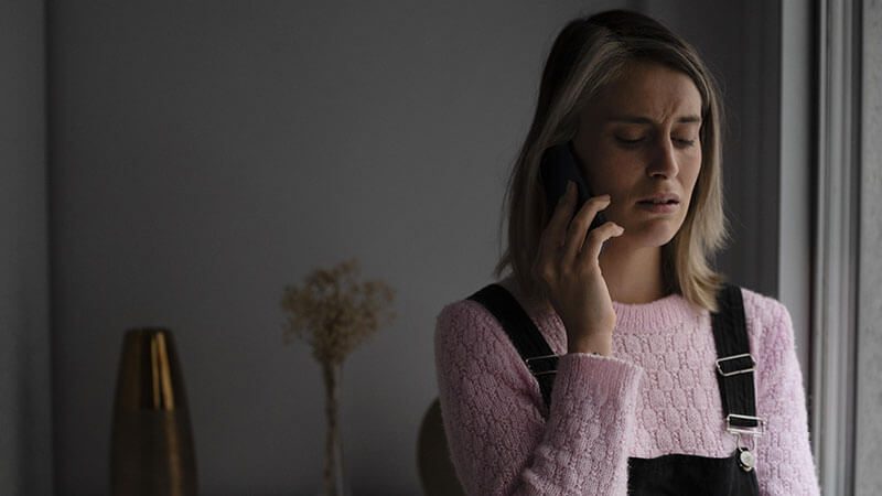 imagem de uma mulher triste falando no telefone