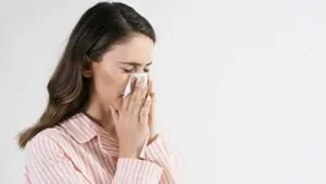 imagem de uma mulher espirrando após tomar antibiótico para sinusite