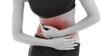 Mulher com a mão na barriga querendo saber se é normal sentir algo mexendo na barriga