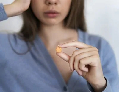 Mulher em dúvida se remédio sublingual pode ser engolido