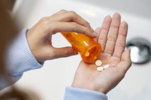 Mulher segurando remédio para febre