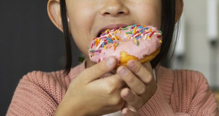 Menina comendo doce tomando remédio de verme