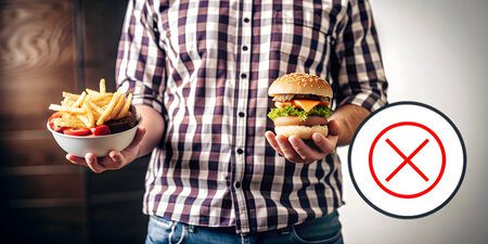 Homem segurando alimentos não saudáveis