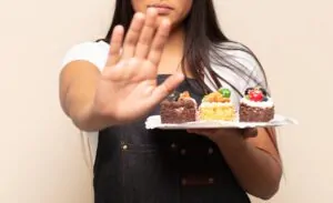 Mulher segurando prato com alimentos que diabético não pode comer