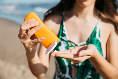 Mulher aplicando protetor solar facial