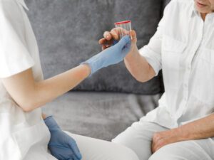 enfermeira entregando pote para coleta de acido úrico alto