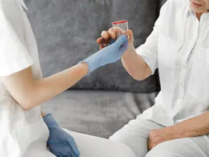 enfermeira entregando pote para coleta de acido úrico alto