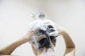 Mulher usando shampoo para caspa