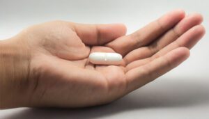 Mulher segurando capsula de Fluconazol para que serve.