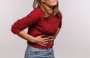 Mulher precisando de chá para dor de barriga