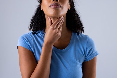 Mulher precisando de autocuidados para dor de garganta